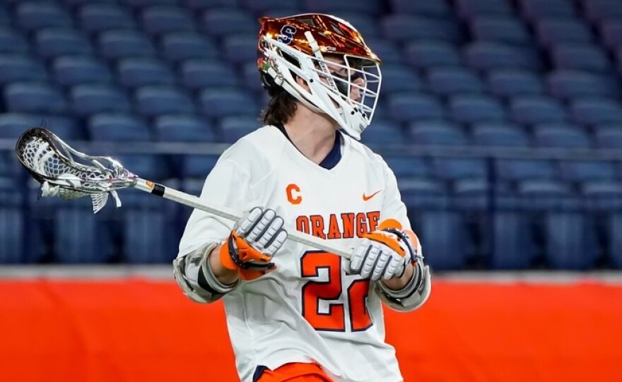 Syracuse attackman Joey Spallina (22, White) looks for an open teammate in No. 2 SU’s 11-9 win over No. 1 Maryland on Friday, February 13.
