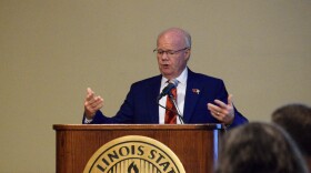 A man in a suit speaks at a podium