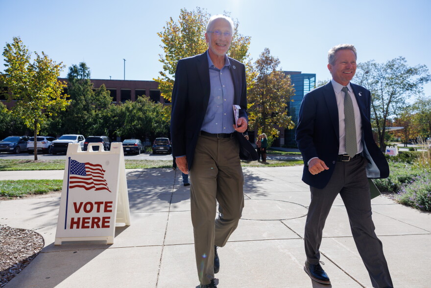 East Lansing Mayor Erik Altmann, left, and Michigan State University President Kevin Guskiewicz, right, enter an early voting site in WKAR's Studio A on Oct. 21, 2026.