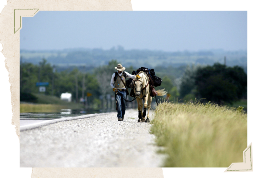 Matt Parker walks alongside his horse, Silver, near Vassar, Kan. Parker is trying to become the first man to cross America on horseback through the American Discovery Trail, which runs from California to Delaware. Starting the journey near Sacramento in 2003, he traveled to Utah before horse problems and winter forced him to stop. In 2004, he resumed the trip with a new horse and traveled to Kansas. He went back to Michigan and began training with a new horse before starting the trail again where he left off in Osage City, Kan.