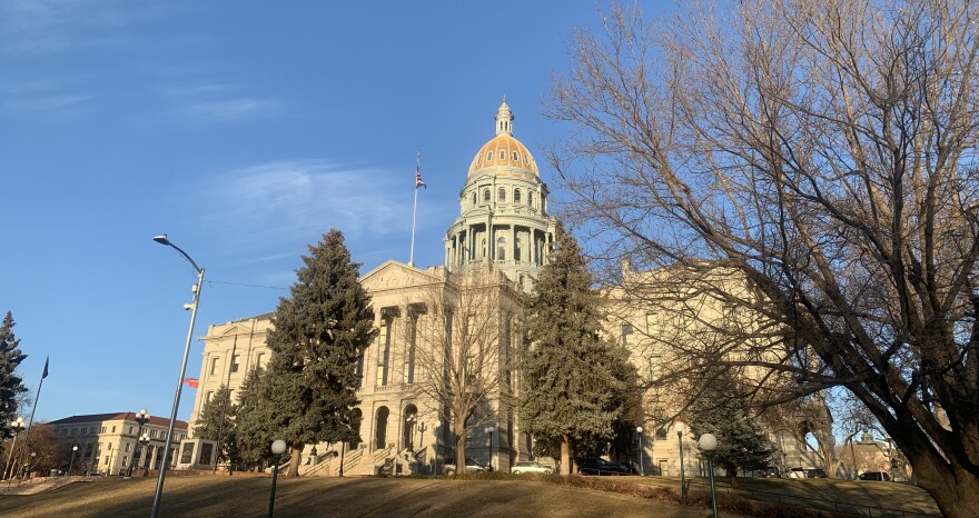 This shows the Colorado State Capitol building at golden hour surrounded by trees. 