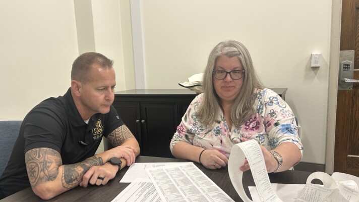 Saginaw police officer Matt Gerow and the city's lawyer Amy Lusk examine the results of the voter tabulation test on Tuesday, Oct. 13, 2026.