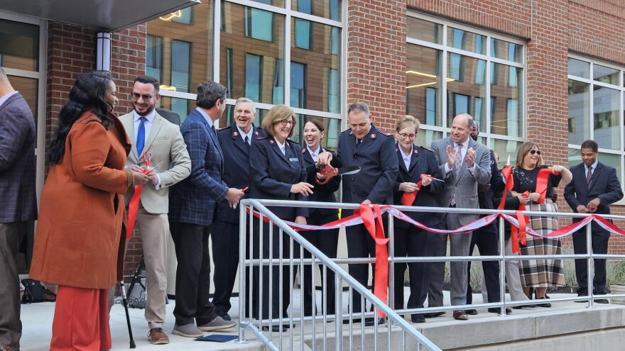 Local civic leaders and Salvation Army members celebrate after the official opening of a new emergency shelter on Buffalo's Main Street.