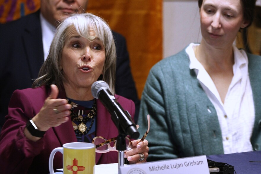 New Mexico Gov. Michelle Lujan Grisham, left, speaks during a news conference, Tuesday, March 10, 2026, in Santa Fe, N.M., after signing legislation that bars federal immigration agents from election polling sites in New Mexico, in a step being considered by several other Democratic-led states.
