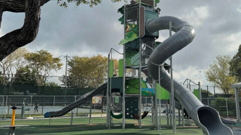 Image of an enclosed gray tube slide at a playground