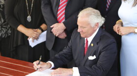 South Carolina Gov. Henry McMaster signs a bill preventing people from suing businesses over COVID-19 on Thursday, June 24, 2021 at Cafe Strudel in West Columbia, South Carolina. The bill signing was ceremonial after the General Assembly passed the legislation in April. (AP Photo/Jeffrey Collins)