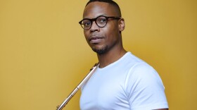 yellow background, closeup of flutist Brandon Patrick George holding instrument