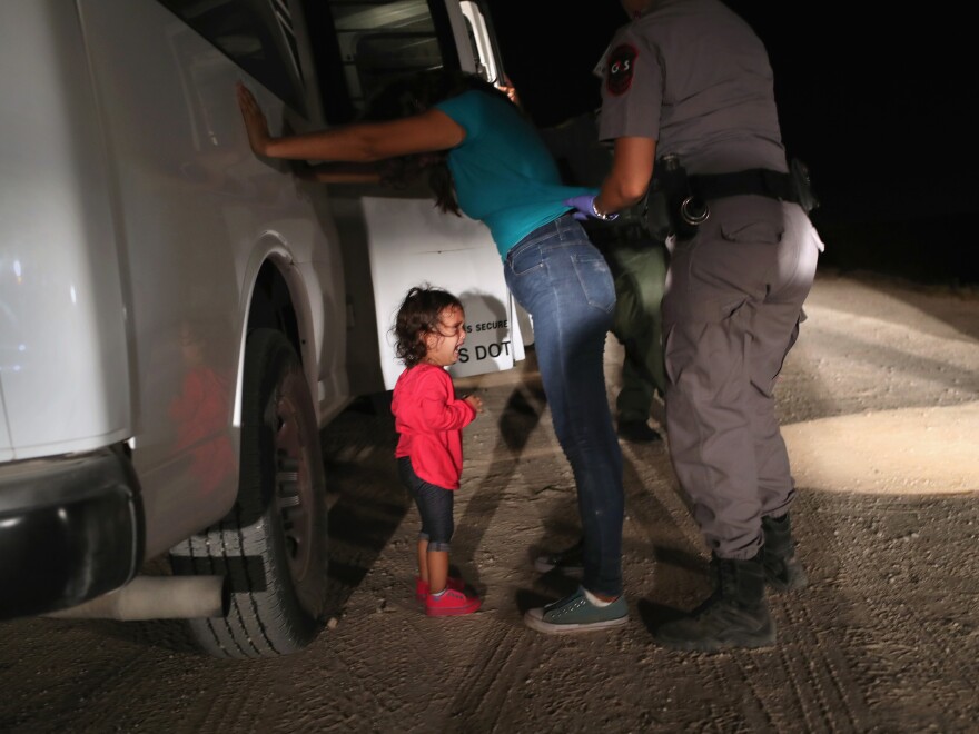 A 2-year-old from Honduras cries as her mother is searched and detained near the U.S.-Mexico border on June 12 in McAllen, Texas.