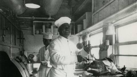 Railroad chef in narrow kitchen cutting turkey, undated.