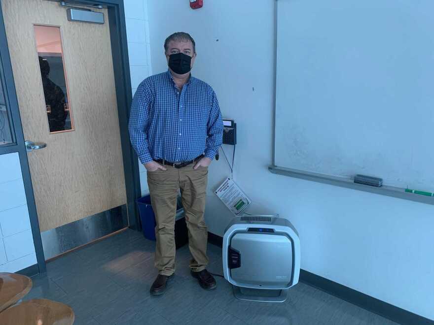 Bridgeport High School English teacher Jeff Morrissette with the air purifier the district purchased for his classroom