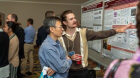 Eddie Rygalski, a PhD student in Virginia Tech's translational biology medicine and health program (right), discusses his poster with another conference participant at the International Biochemistry of Exercise Conference in Roanoke.