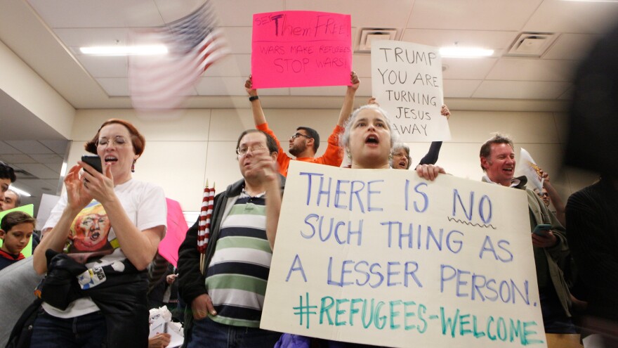 Protesters gather at Dallas-Fort Worth International Airport to denounce President Trump's executive order that bans certain immigration.