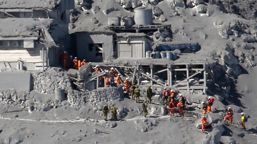 Rescue workers and Self-Defense Force soldiers search for missing climbers and survivors among ash-covered mountain cottages on the top of Mount Ontake in central Japan.