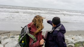 Winfred Obruk (right) from Shishmaref, Alaska shows Amy Martin (right) where the island used to be before erosion, caused in part by climate change, ate away at the island.