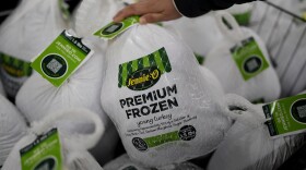 A shopper checks premium frozen young turkey at a grocery store in Glenview, Ill., Monday, Nov. 25, 2024.