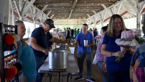 Angie Barron (left) and her husband Danny Barron (second from left) interact with customers at the Makers Market at the Trenton Train Depot on Friday, March 13, 2026. (Victoria Perez/WUFT News)