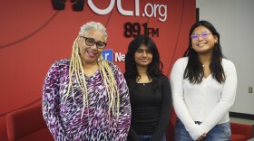 Three women stand in a row smiling for a picture