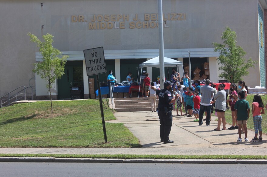 Families line up, masked and social distanced at the walk-up, Back-To-School give away, where they will receive PPE, backpacks and supplies.