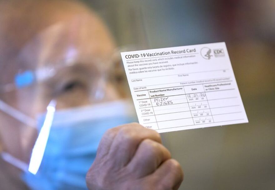 Blanca Rokstad, CNA at Rose Villa in Portland shows her vaccination record after receiving the Pfizer COVID-19 vaccine on Monday, Dec. 21, 2020. The facility says it is Oregon's first long term care facility to receive the vaccine, and planned to vaccinate 145 staff and 35 24-hour care residents.