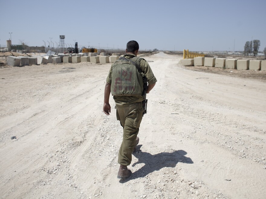 An Israeli soldier walks near the border between Israel and Egypt at the Kerem Shalom border crossing on Wednesday.