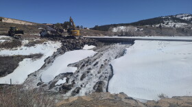 In this photo provided by the Utah Division of Water Rights, crews use heavy machinery to place boulders downstream of the cracked Panguitch Lake Dam to reinforce the wall, Wednesday, April 10, 2024, in Panguitch, Utah.