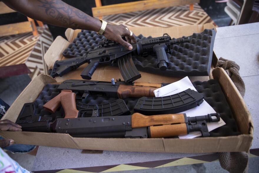  A Haitian gang member in Port-au-Prince inspects U.S.-made AK-47 assault rifles smuggled into the country last month.