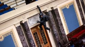 A protester is seen hanging from the balcony in the Senate Chamber on January 06, 2021 in Washington, DC.