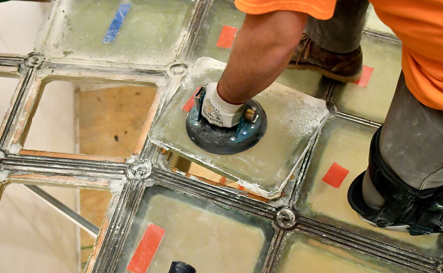 Man replacing the glass in the floor