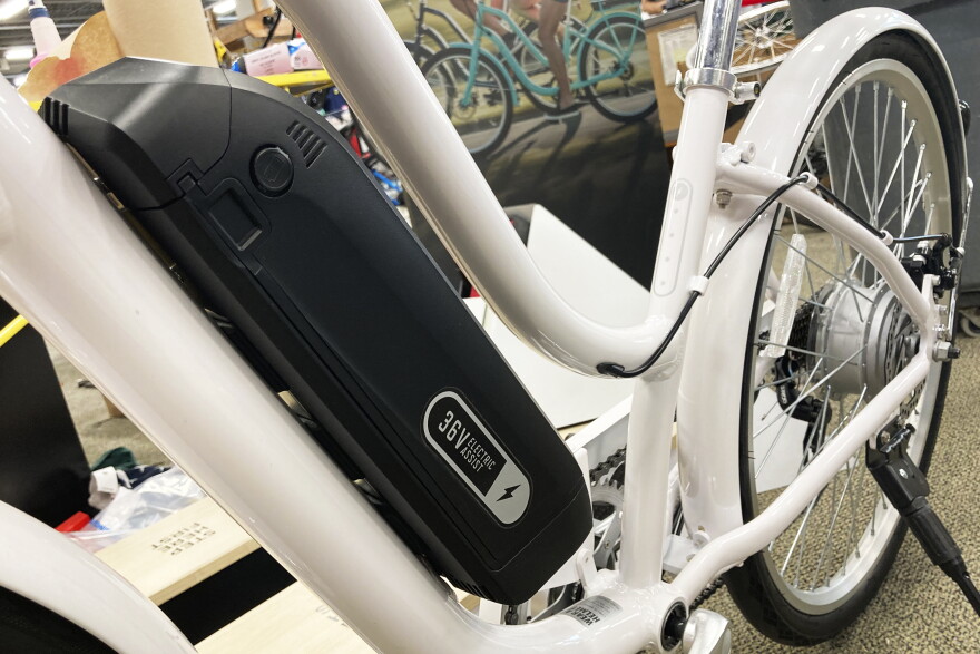 an electric motor sits along the frame of a white bicycle