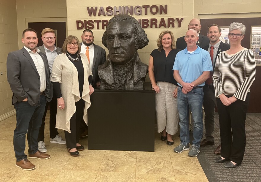 The new Washington City Council gathers around a bust of George Washington displayed at Five Points Washington. The bust was loaned to Washington by the city of Peoria to help Washington celebrate its bicentennial. From left are Todd Sluder, Brandon Moss, Mayor Lilija Stevens, Mike McIntyre, Jamie Smith, Michael Ernst, John Blundy, Bobby Martin III and Paula Johnson.