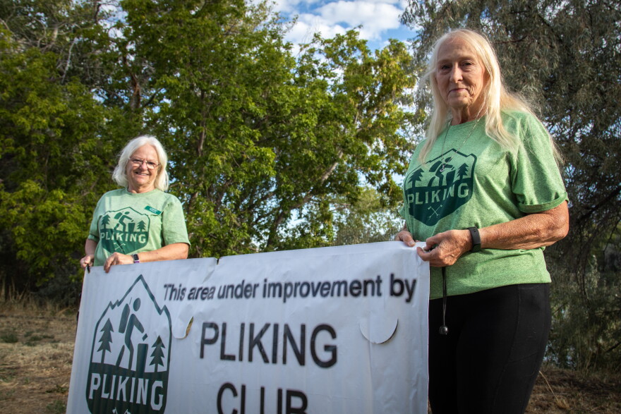 Directors Lyndsey Sorrentino and Cherie Malone hold up the Pliking banner at the 21st Street Pond in Ogden, Sept. 12, 2026.