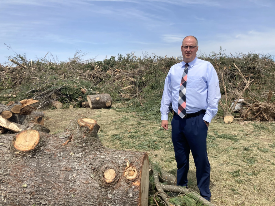 Gaylord Chief of Police Frank Claeys stands in front of a pile of trees at the Otsego County fair grounds on May 24, 2022.