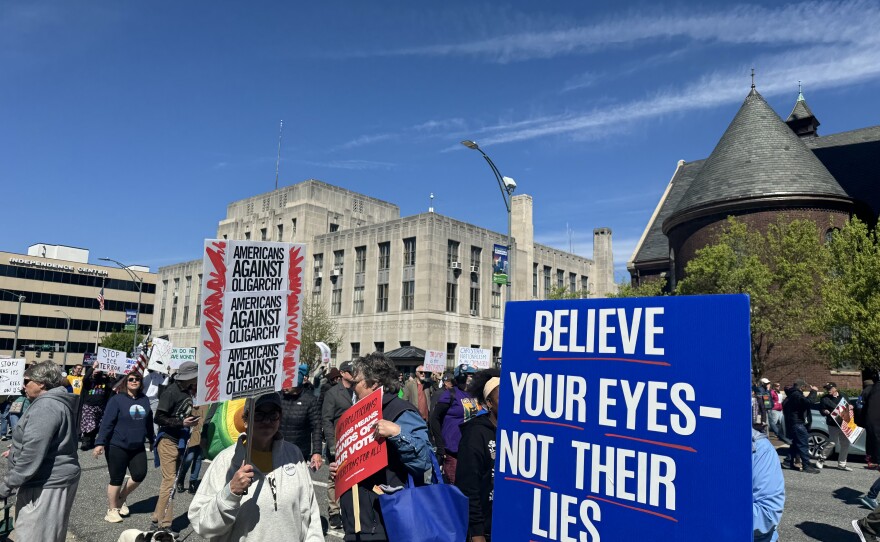 A photo of people gathered in downtown Greensboro with signs.