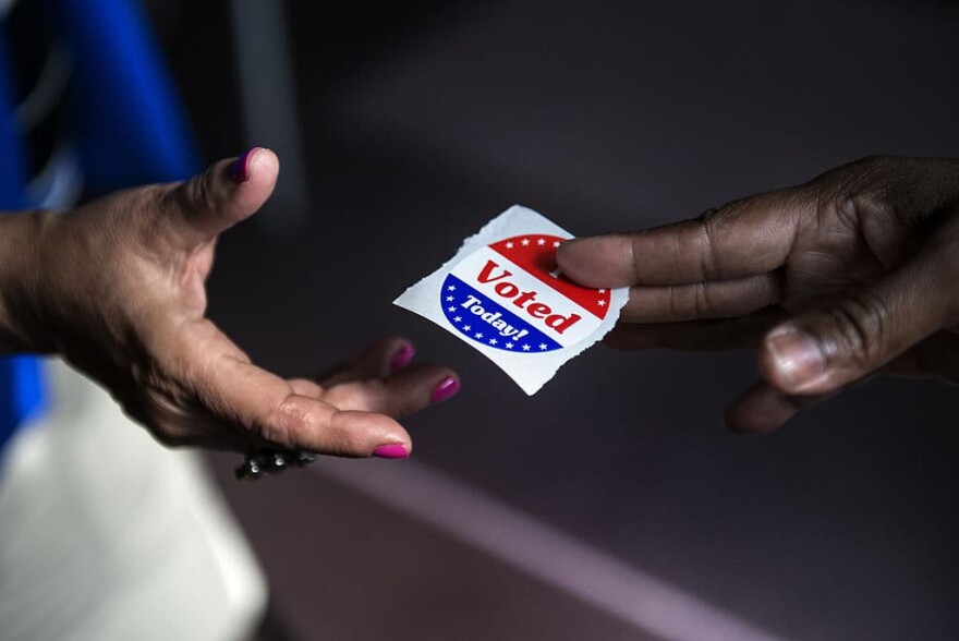 A poll worker hands out "I Voted Today" stickers. (Brendan Smialowski/AFP/Getty Images) 