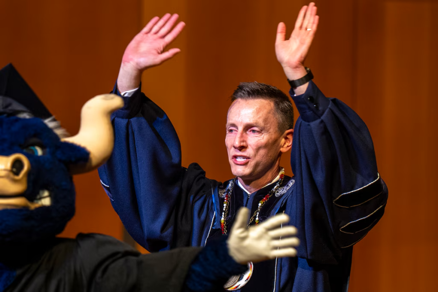 Utah State University President Brad Mortensen raises his hands during his inauguration ceremony as "The Scotsman" plays.