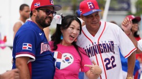 Bonnie Ramirez, center, a supporter of the South Korea baseball team, poses with Dominican Republic fans before a World Baseball Classic game between the Dominican Republic and South Korea, Friday, March 13, 2026, in Miami.