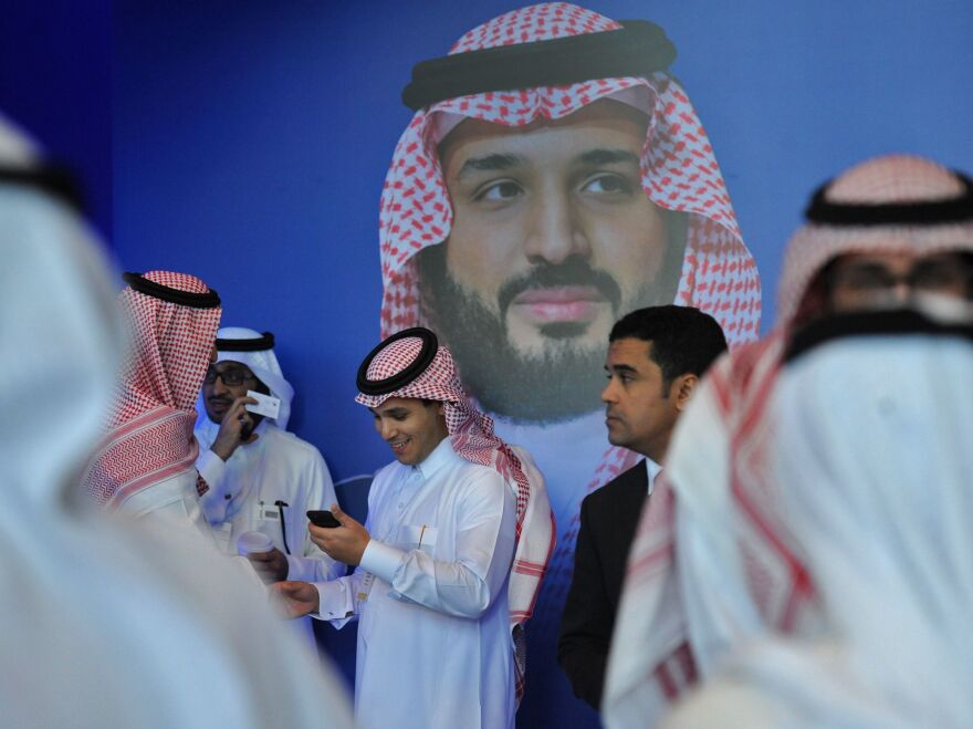 Saudi men chat in front of a poster of Saudi Crown Prince Mohammed bin Salman at an international gathering in Riyadh in November. Social liberalization is being driven by the 32-year-old crown prince, who launched an ambitious plan called Vision 2030 to open the kingdom, diversify its economy and create jobs, especially for young people.