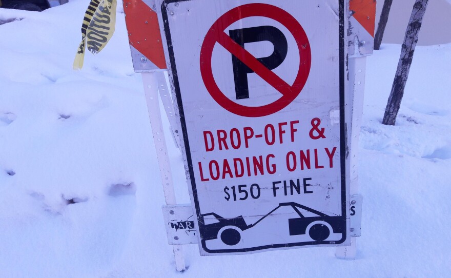 A red and white no parking sign