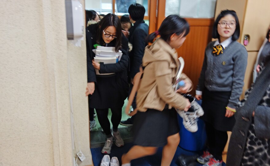 Students take off their shoes before entering the study hall.