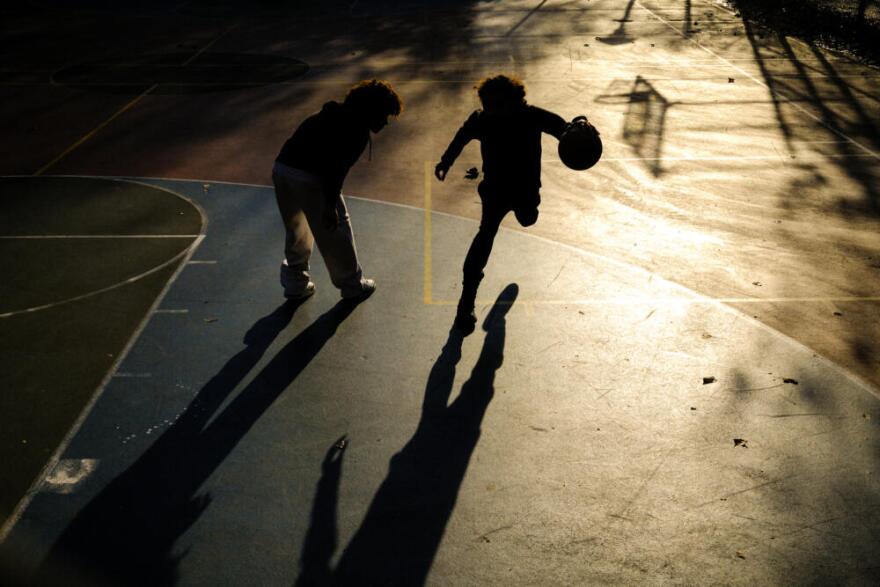 Young boys play basketball on a playground in the Hamilton Heights neighborhood of Manhattan in New York City on November 19, 2025. (Charly Triballeau/AFP via Getty Images)