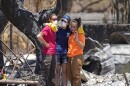 Women hug after digging through rubble of a home destroyed by a wildfire on Friday, Aug. 11, 2023, in Lāhaina, Hawaii.