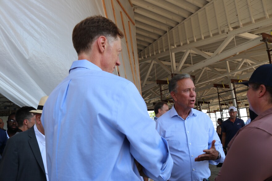Governor Ned Lamont (D) speaks with Mayor Justin Elicker (D) and city Tree Warden Annie Mixsell inside of the carousel building.