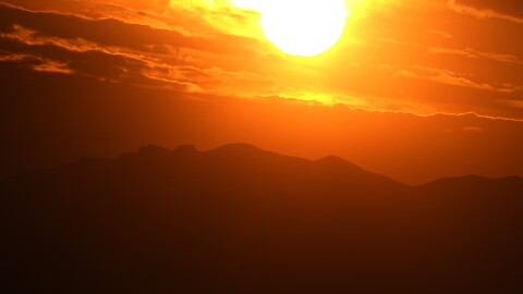 The setting sun illuminates the clouds over the Rocky Mountains.