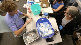 Volunteers Laurel Taylor and Isaac Bowlin package two syringes and two doses of Naloxone to be distributed later by OKHRA in Tulsa.