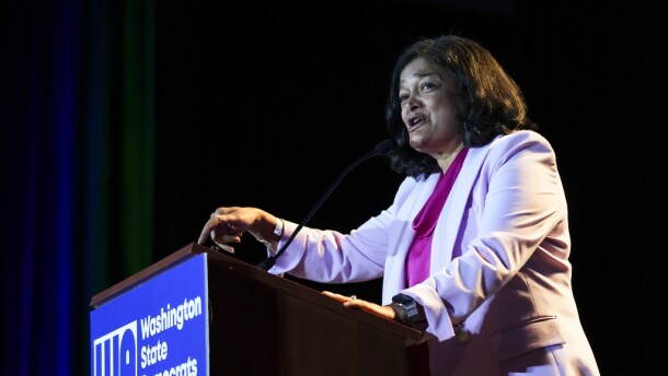 A woman stands and speaks at a podium.