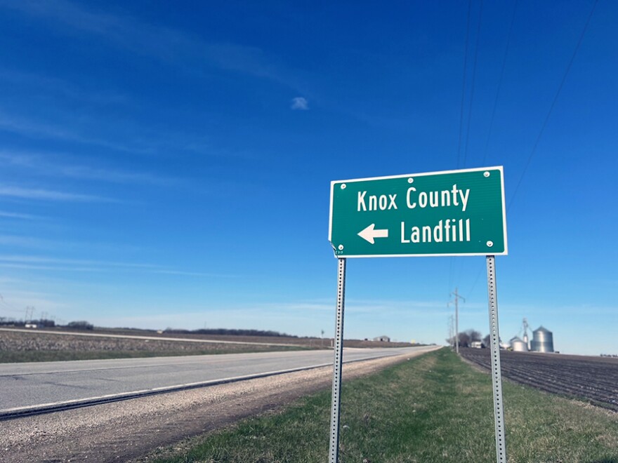 A green sign pointing to the Knox County landfill. 