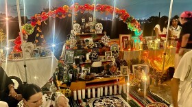 Community members gather in front of altar at the Day of the Dead ceremony  by Mitotiliztli Yaoyollohtli, an Indigenous dance group in Dallas. 