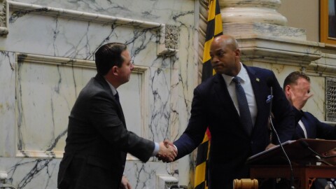 Gov. Wes Moore offers a hand shake to Senate President Bill Ferguson after commenting on their disagreement over early redistricting during his State of the State address on Wednesday in the House Chamber in Annapolis, Md.