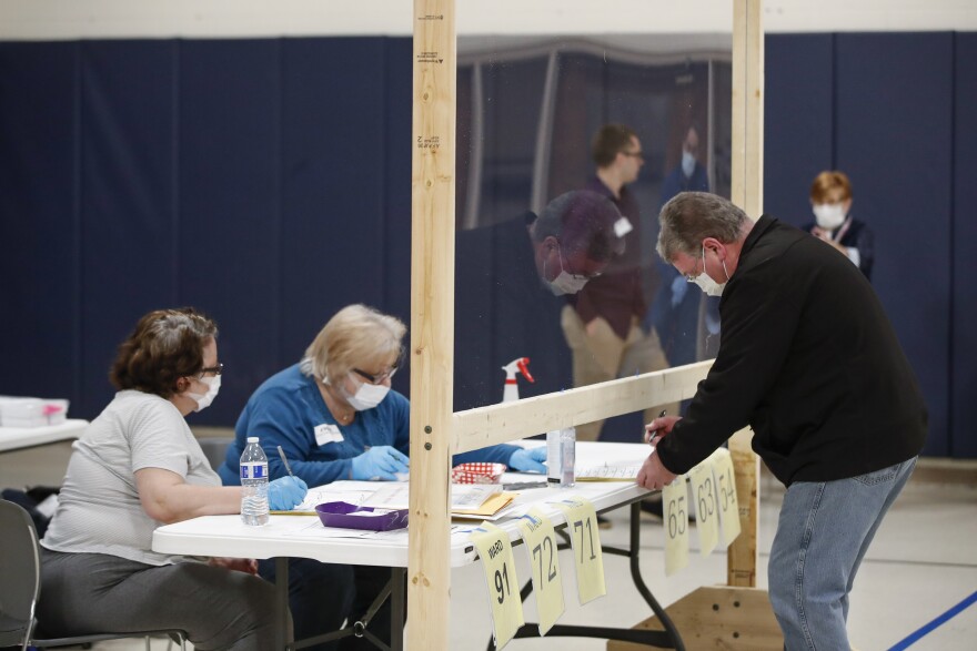 A man checks to cast his ballot in Kenosha, Wis., on April 7. A new study suggests that in-person voting in that Wisconsin primary did not produce a surge of new coronavirus cases.