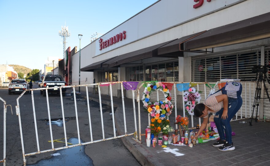 Alma Paredes lights a candle at an alter outside Waldo's in downtown Hermosillo store on Monday, Nov. 3, 2025, the day after an explosion there killed 23 people, including children.
